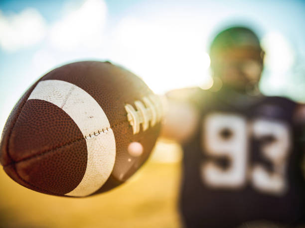 istock Football in the hands during game 1254083981