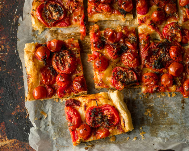 istock Sliced homemade tomato tart on baking tray, top view 1254085436