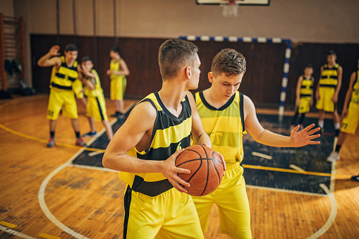 Group of men, teenage boys basketball players on training indoors.