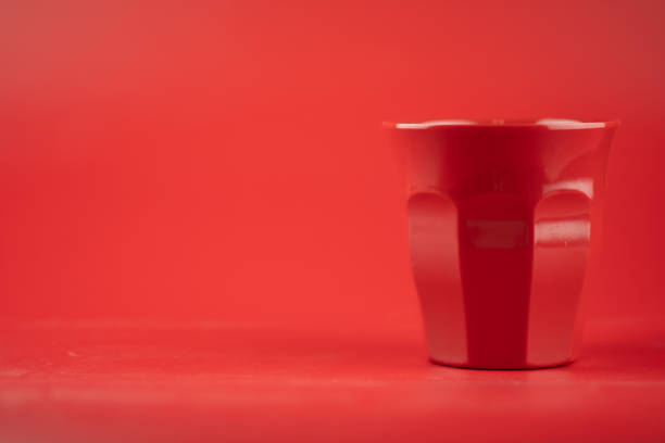 istock Red plastic glass on red background with copy space 1254085795