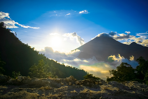 sunset landscape with volcano and zunil valley with clouds and sun shining