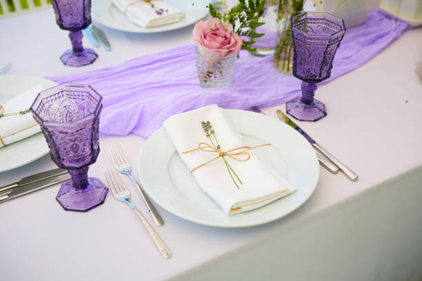 istock Elegant table setting for wedding engagement Easter dinner with white ceramic plates cotton napkin tied with twine lavender flowers candles. Provence style 1254087216