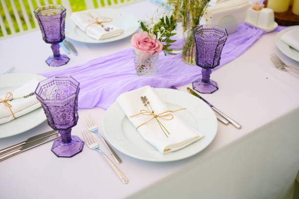 istock Elegant table setting for wedding engagement Easter dinner with white ceramic plates cotton napkin tied with twine lavender flowers candles. Provence style 1254087224
