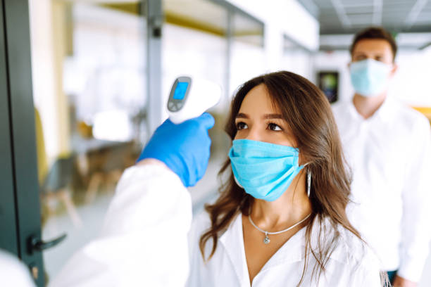 istock Visitors must go through fever measures using infrared digital thermometer check temperature measurement on the forehead. 1254089858