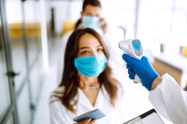 istock Visitors must go through fever measures using infrared digital thermometer check temperature measurement on the forehead. 1254089922