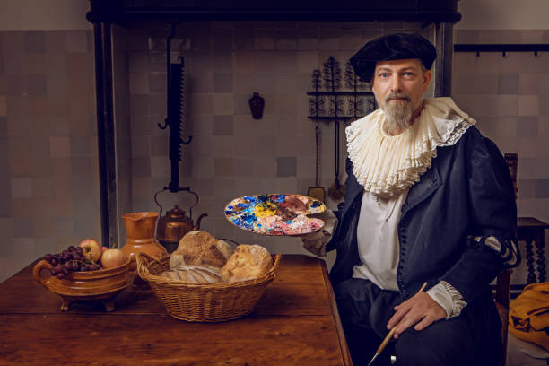 Portrait of a traditional dutch nobleman at a kitchen table Portrait of a handsome traditional dutch nobleman wearing historically correct outfit whilst sitting at a table in a typical townhouse kitchen renaissance style stock pictures, royalty-free photos & images