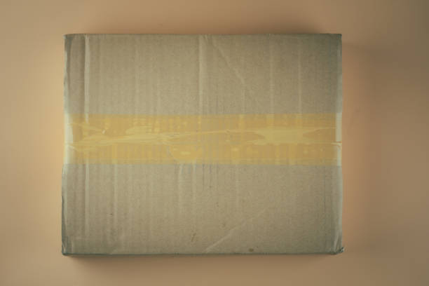 istock Used brown parcel box on orange background. Top view 1254091062