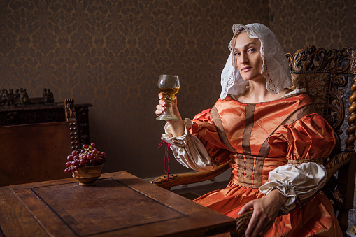 Portrait of a beautiful historical dutch noble woman wearing historically correct outfit in a typical townhouse drawing room scene
