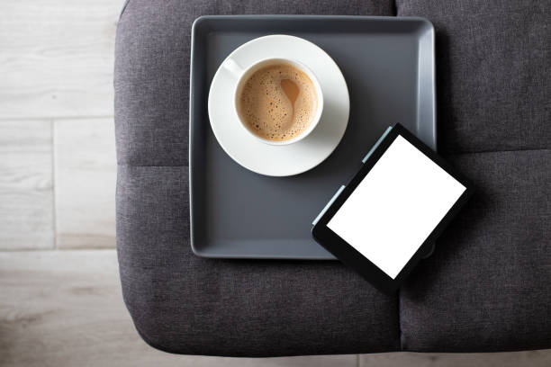 mockup ebook на современном кресле с пустым белым экраном, чтобы заменить ваш дизайн и кофе для уютного чтения атмосферы - e reader digital tablet cafe reading стоковые фото и изображения