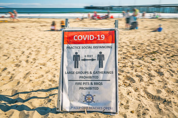 « covide-19 » signe d’avertissement sur la plage dans la petite ville de plage belle avila beach, californie. - san luis obispo county photos et images de collection