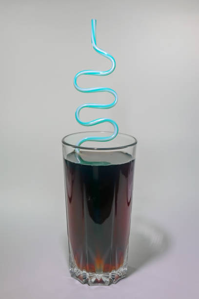 un verre de boisson gazeuse avec un tuyau sur un fond léger - cocktail nobody close up fruit photos et images de collection