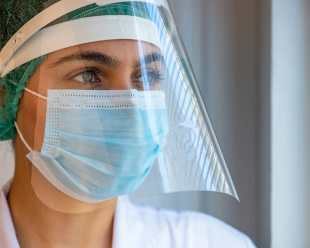 istock Closeup female doctor wearing face shield and PPE suit 1254103537