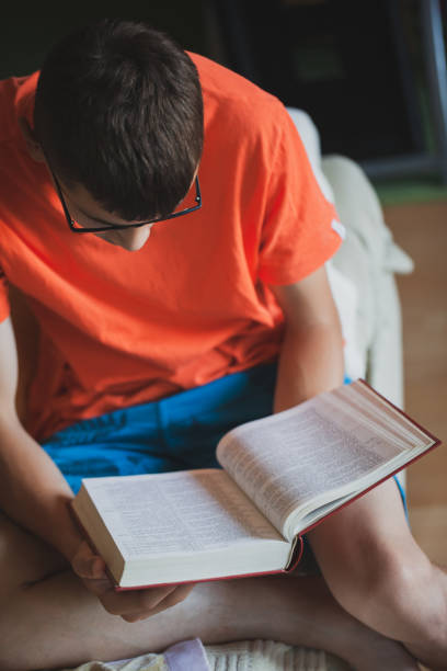 istock Teenager reading book 1254113904