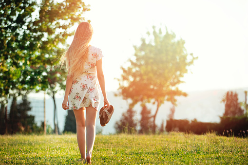 young woman walking at sunset