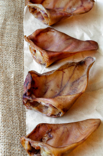 istock Four dried pork ears on burlap. 1254114399