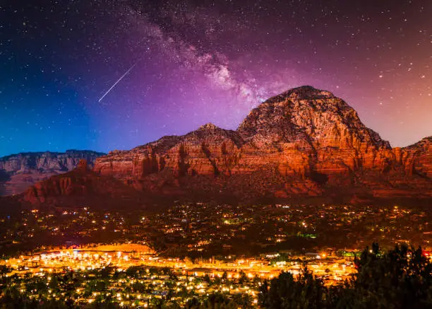 Beautiful Milky Way Galaxy stars over Sedona Arizona landscape with city lights.