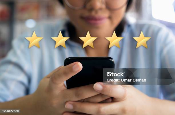 Woman Using Cell Phone With 5 Gold Star Customer Satisfaction Graphic Stock Photo - Download Image Now