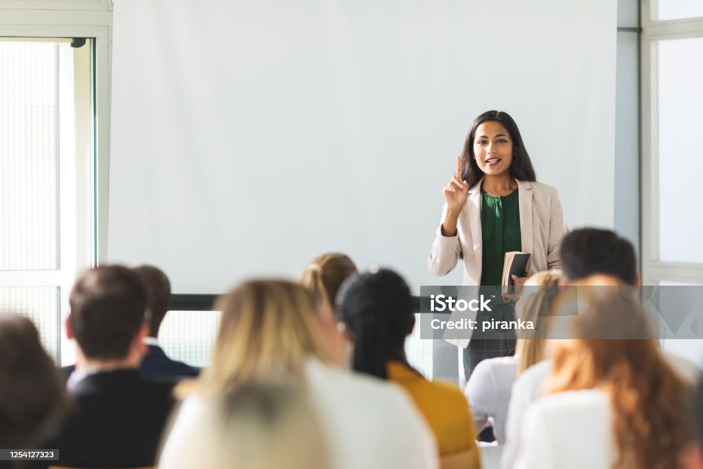 Businesswoman holding a speech Businesswoman of Indian descent speaking at a seminar Education Training Class Stock Photo