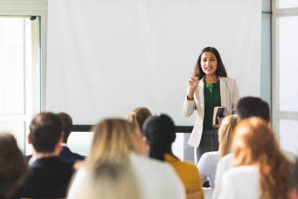 Businesswoman holding a speech Businesswoman of Indian descent speaking at a seminar seminar stock pictures, royalty-free photos & images