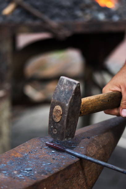 istock Blacksmith working metal with hammer on the anvil in the forge 1254128152