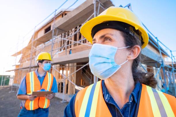 istock Mature female construction worker looking at the camera wearing a protective face mask 1254132039