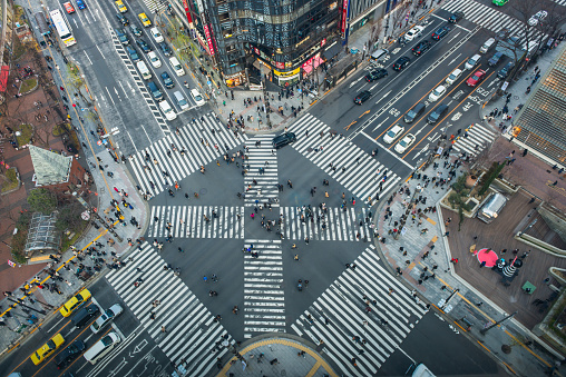 Crowds of shoppers, commuters and tourists on an iconic pedestrian crossing the popular shopping district of Ginza, below the neon billboards of downtown Tokyo, Japan’s vibrant capital city.
