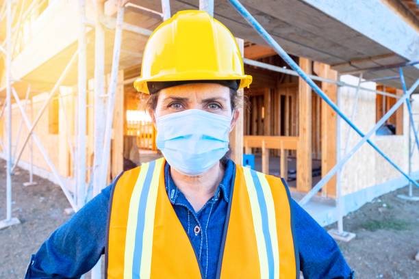 istock Mature female construction worker looking at the camera wearing a protective face mask 1254136036