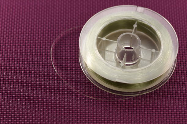 istock Fishing line on spool isolated on  purple 1254137918