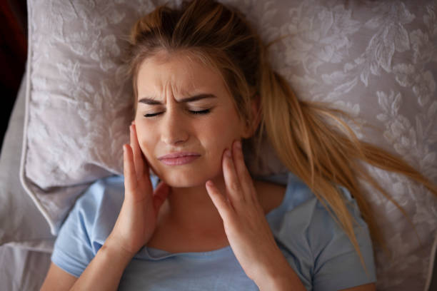 Jaw pain after waking up or sleeping, TMJ Bruxisum, teeth grinding Bruxism or teeth grinding in sleep cheek photos stock pictures, royalty-free photos & images