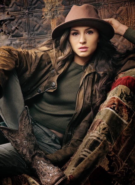 istock brunette in ralph lauren tones holding onto hat 1254141559
