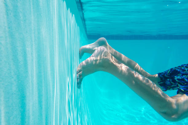 This underwater photo shows a swimmer kicking off the wall in a swimming pool to launch himself forward.