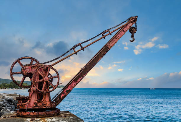 istock Old Red Rusty Crane by Sea at Dusk 1254149203