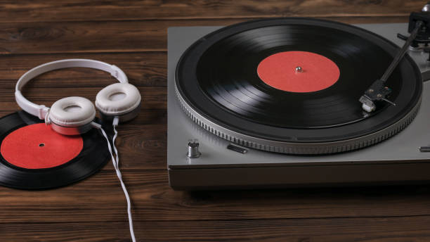 istock White headphones with a wire are connected to a vinyl disc player. 1254156372