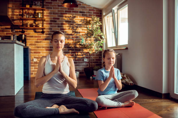 istock Mother and Daughter doing Yoga 1254159111