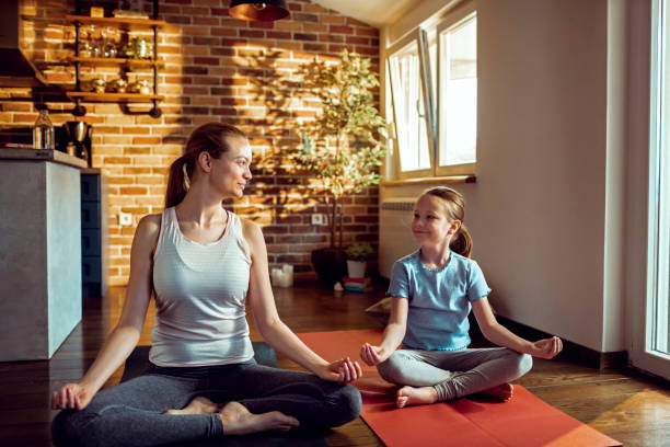 istock Mother and Daughter doing Yoga 1254159760