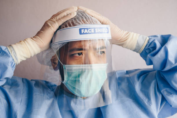 istock Doctor having headache and tired from work while wearing PPE suit for protect coronavirus disease. 1254163428