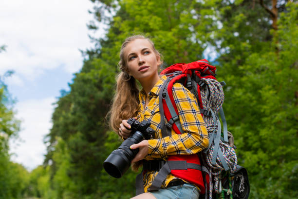 istock Female hiker looking by side and holding photocam with both hands 1254164459