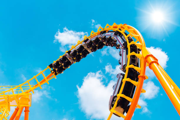 vagão ferroviário montanha-russa sem pessoas testando pista alta até a curva do rolo do céu e torcer para pessoas divertidas emocionantes no parque temático durante coronavírus (covid-19) pandemia - rollercoaster - fotografias e filmes do acervo