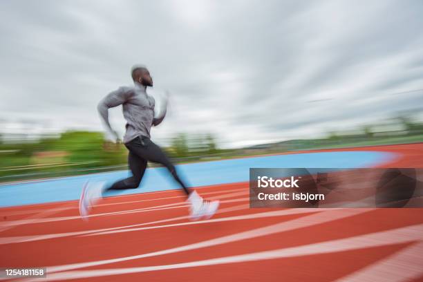 Young African American Man Running At Tartan Stock Photo - Download Image Now - Running Track, Sprint, Blurred Motion