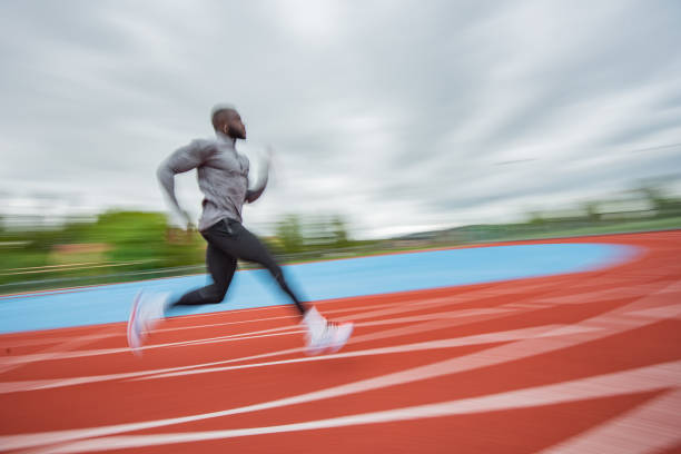 молодой афроамериканец, бегущий на тартане. - running speed track event jogging стоковые фото и изображения