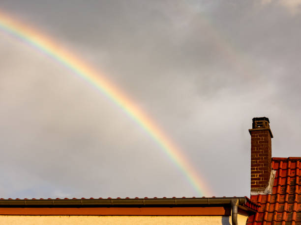 istock Colorful rainbow in a grey cloudy rainy sky 1254191127