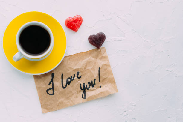 istock Yellow cup of coffee on a white background. Note I love you. Copy space 1254192023