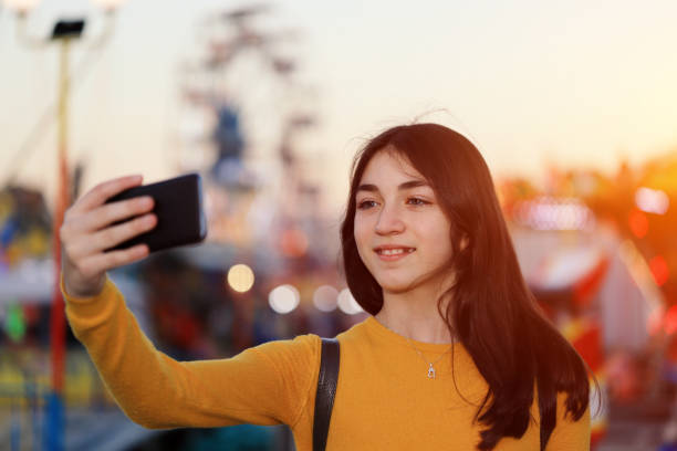 istock Girl taking selfie in amusement park 1254192757