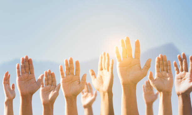istock People raising hands for participation, many people's hands up. teamwork and competition concept 1254196353