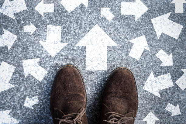 istock man standing on road with many direction arrow choices or move forward. concept solution and start. 1254197039