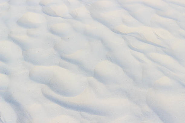 istock Wavy texture of white sand, background 1254197489