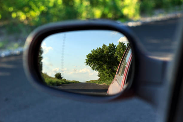 istock trees and highway in car rearview mirror 1254197523