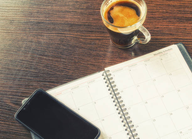 istock Mobile phone, open notebook, cup of coffee on the wood table. 1254202008