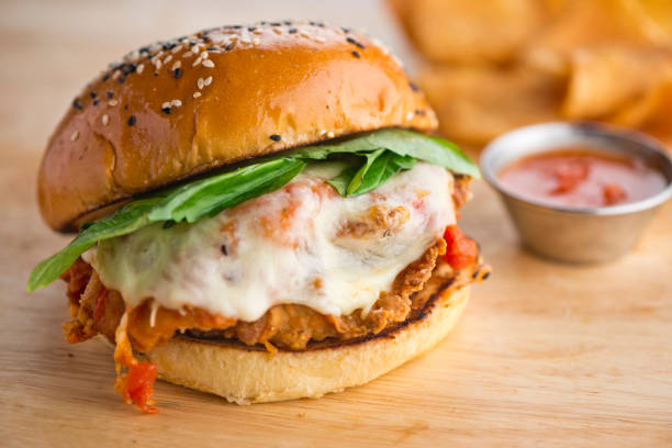 istock Chicken sandwich served with grilled or fried chicken breast on toasted grain bread w/ melted Swiss cheese, sautéed onions, lettuce, tomato, mayonnaise and seasoned salt and pepper. Classic American restaurant or diner lunch sandwich favorite. 1254202097