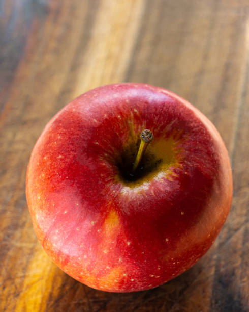 istock Red apple lies on an oak board. 1254205668